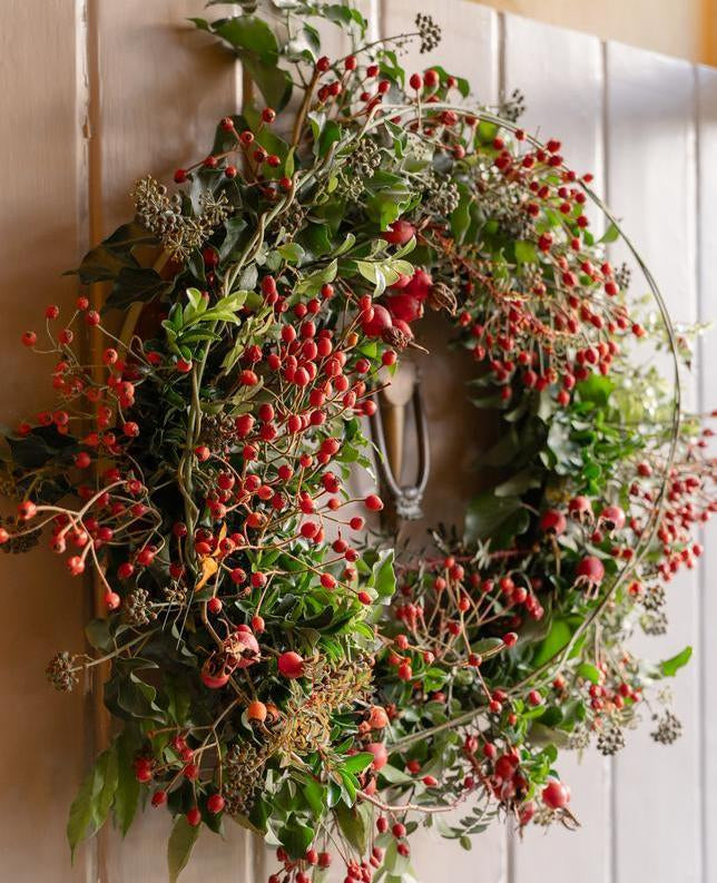 Red rose hip wreath hanging on a door